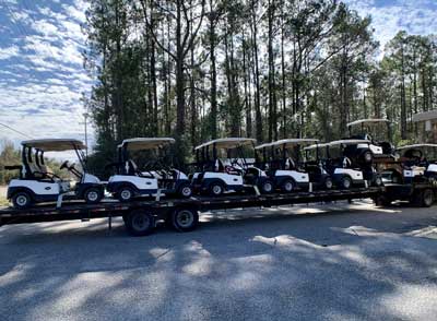 many golf carts on trailer